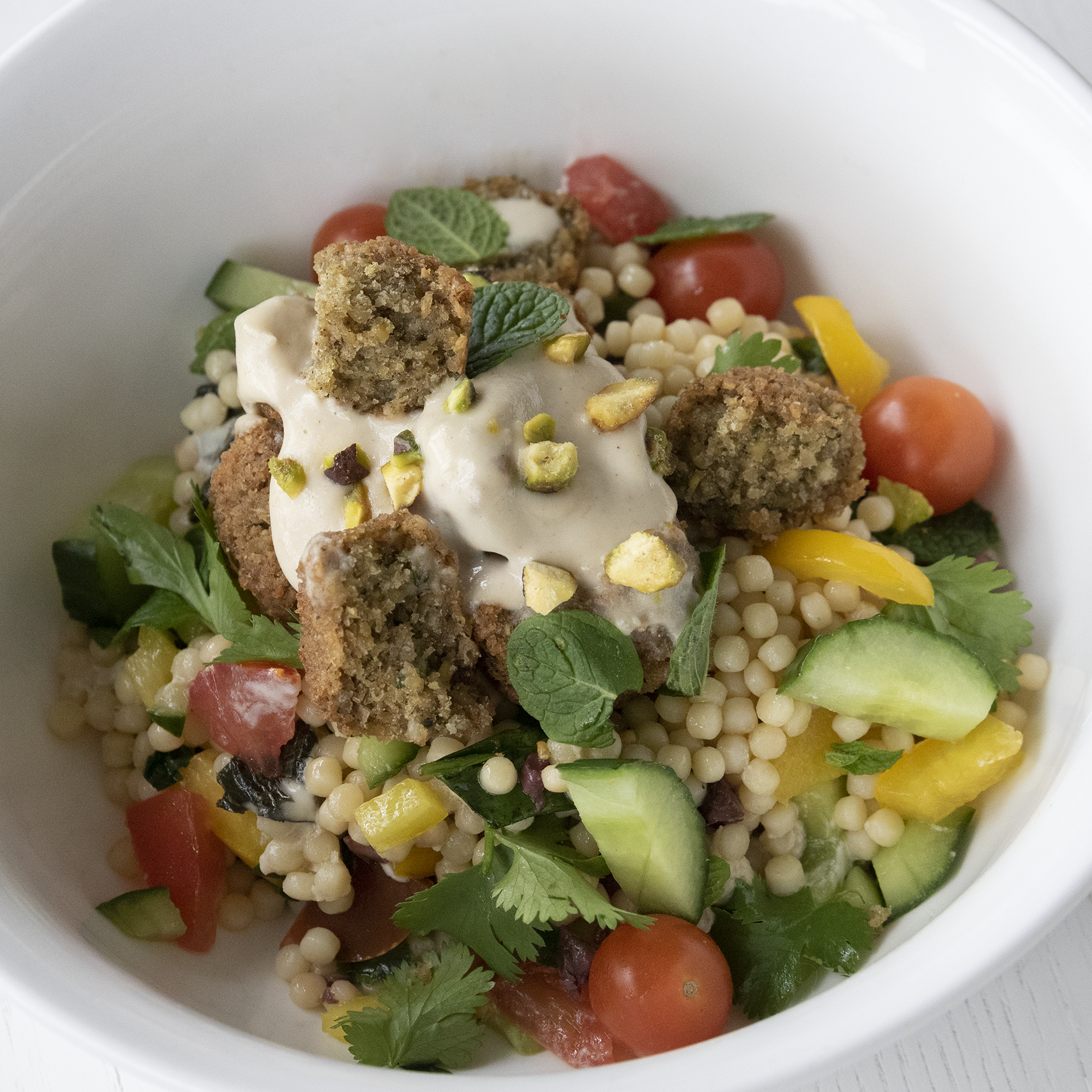 Easy and quick Falafel on a bed of steamed couscous which is loaded with herbs and crispy chunks of vegetables is unbeatable
